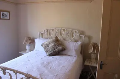 a bedroom with a white bed with two lamps at BlesBok House in Erasmus