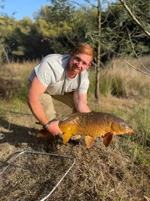 a man holding a large fish in a field at BlesBok House in Erasmus
