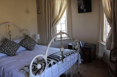 a bedroom with a white bed and a window at BlesBok House in Erasmus