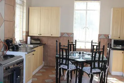 a kitchen with a table with chairs and a sink at BlesBok House in Erasmus