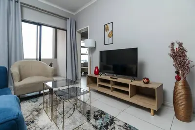 a living room with a tv and a blue couch at Smart Apartment 17 in Erand