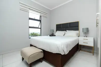 a white bedroom with a large bed and a chair at Smart Apartment 17 in Erand