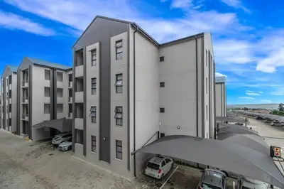 a large white building with cars parked in a parking lot at Smart Apartment 17 in Erand