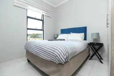 a white bedroom with a large bed and a window at Smart Apartment 17 in Erand