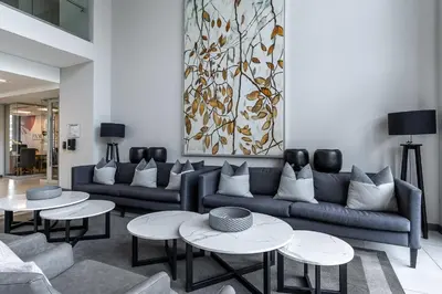 a living room with couches and tables and a painting at 11 Floors in the Sky - Luxurious 1 Bedroom in Pretoria