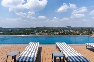 two benches sitting on a deck next to a swimming pool at 11 Floors in the Sky - Luxurious 1 Bedroom in Pretoria