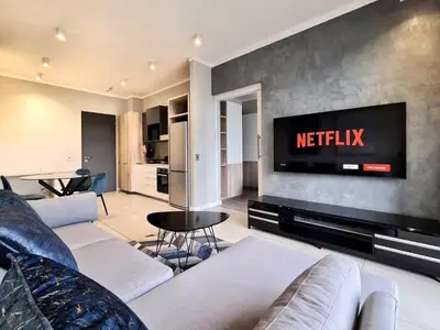 a living room with a couch and a television at 11 Floors in the Sky - Luxurious 1 Bedroom in Pretoria