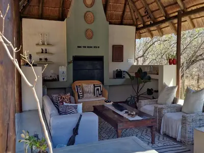a living room with two couches and a table at The Dreamcatcher Lodge in Hoedspruit