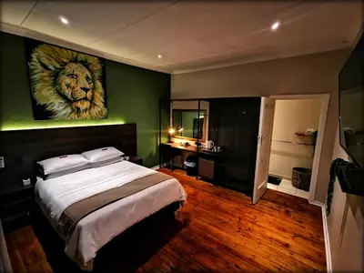 a bedroom with a bed with a lion painting on the wall at Cozy Manor Guestrooms in Lyttelton