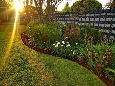 a garden with flowers and a fence at Cozy Manor Guestrooms in Lyttelton
