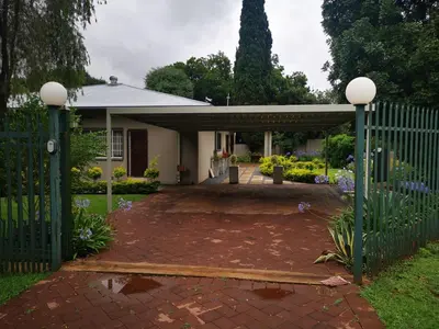 a house with a gate and a brick driveway at Cozy Manor Guestrooms in Lyttelton