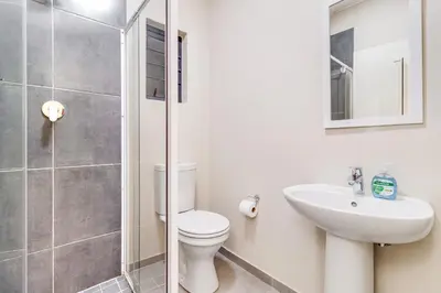 a bathroom with a toilet and a sink and a shower at The Lillies Luxury Apartment in Midrand