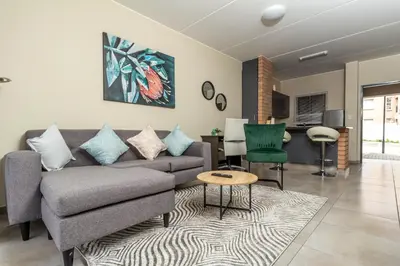 a living room with a couch and a table at The Lillies Luxury Apartment in Midrand