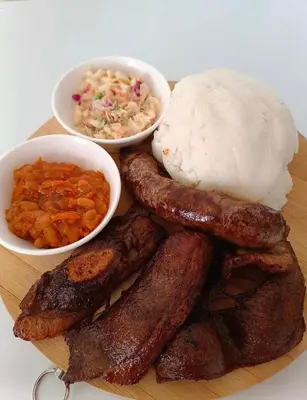 a plate of food with sausages and rice and sides at KO'THABENG GUESTHOUSE in Lebowakgomo