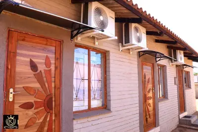 a house with two windows and a door with two air conditioners at KO'THABENG GUESTHOUSE in Lebowakgomo