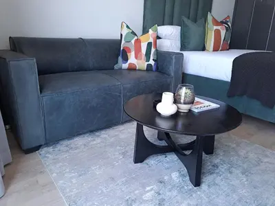 a living room with a couch and a coffee table at Executive Apartment at Ellipse Waterfall in Midrand