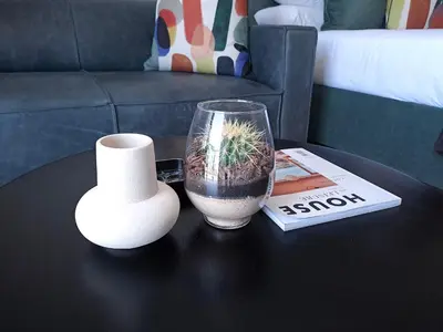 a table with a vase and a plant in a glass at Executive Apartment at Ellipse Waterfall in Midrand