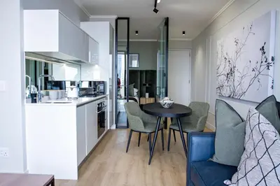a kitchen and living room with a table and chairs at Executive Apartment at Ellipse Waterfall in Midrand