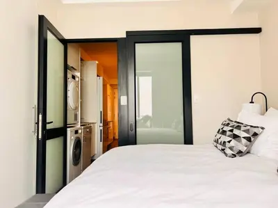 a bedroom with a large white bed with a sliding glass door at The Regency Cozy Apartment- 629 in Pretoria