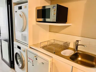 a small kitchen with a sink and a microwave at The Regency Cozy Apartment- 629 in Pretoria