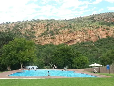 a large swimming pool with a mountain in the background at On Golden Pond - Mount Amanzi in Hartbeespoort