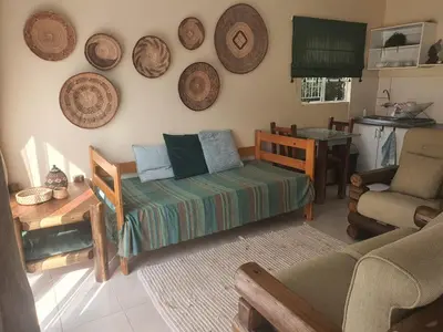 a living room with a couch and plates on the wall at KatiKati Eco Lodge in White River
