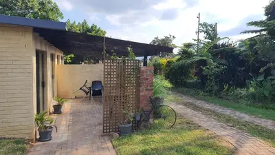 a patio with a fence and a table and chairs at KatiKati Eco Lodge in White River