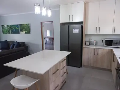 a kitchen with a counter and a black refrigerator at Make a memory in Marloth Park