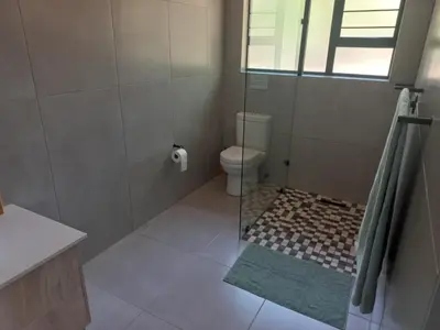 a bathroom with a toilet and a glass shower at Make a memory in Marloth Park