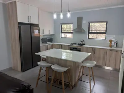 a kitchen with a white counter top and a refrigerator at Make a memory in Marloth Park