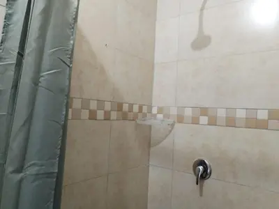 a shower with a glass door with a shower at The Rose Guesthouse in Witbank