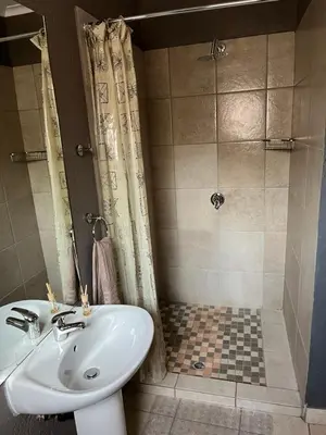 a bathroom with a sink and a shower at Mlakalaka Guesthouse in KuMcogwaba