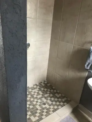 a bathroom with a shower with a sink at Mlakalaka Guesthouse in KuMcogwaba