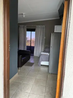 a living room with a bed and a couch at Mlakalaka Guesthouse in KuMcogwaba