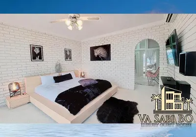 a bedroom with a bed and a white brick wall at Va sabi bo, Best View, Luxury Family Villa in Hartbeespoort Dam in Hartbeespoort