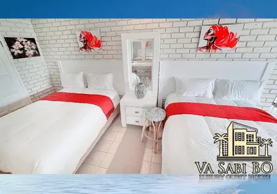 two beds in a white room with red accents at Va sabi bo, Best View, Luxury Family Villa in Hartbeespoort Dam in Hartbeespoort