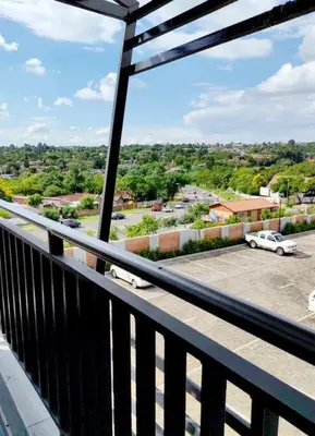 a balcony with a view of a parking lot with a car at Modern 2 bedroom at Waterfall Ridge-Midrand in Midrand