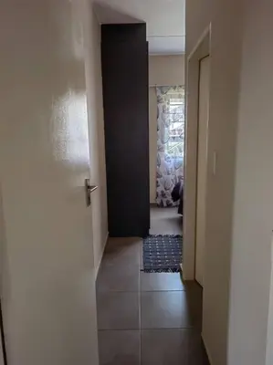 a hallway with a black door and a tile floor at Modern 2 bedroom at Waterfall Ridge-Midrand in Midrand