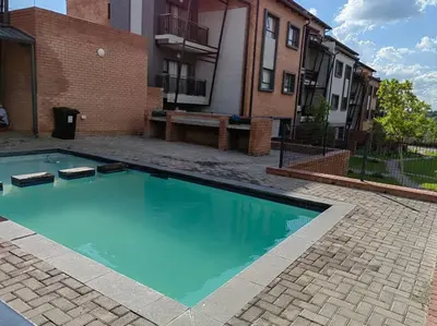 a large blue swimming pool in front of a building at Modern 2 bedroom at Waterfall Ridge-Midrand in Midrand