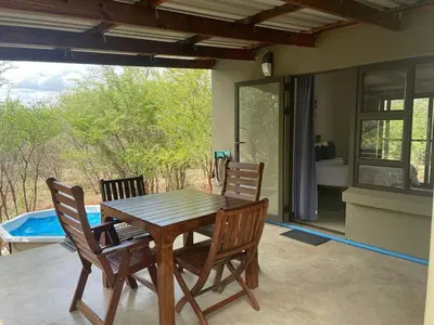 a wooden table and chairs on a patio at African Olive in Hoedspruit