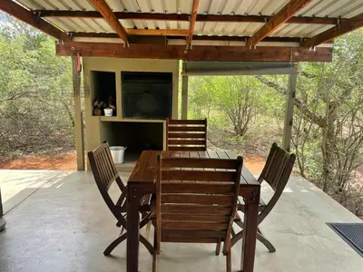 a wooden table and chairs on a patio at African Olive in Hoedspruit