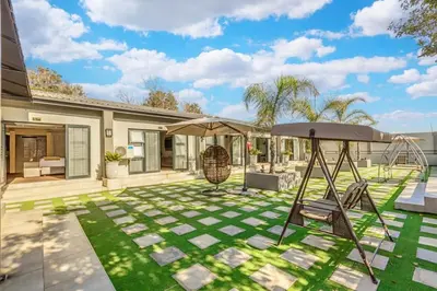 a patio with a swing and an umbrella at Summit Della Suite in Centurion