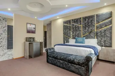 a bedroom with a large bed and a large wall at Summit Della Suite in Centurion