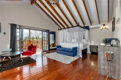 a living room with a blue chair and a table at Summit Della Suite in Centurion