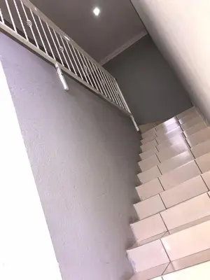 a staircase in a building with a metal railing at Black Owl Lodge in Kempton Park