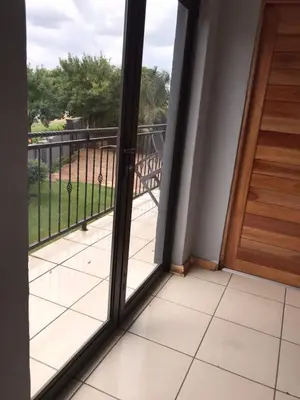 a balcony with a door and a view of a yard at Black Owl Lodge in Kempton Park
