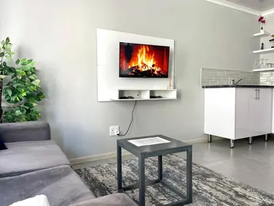 a living room with a fireplace on the wall at Reros Apartments in Mankweng in Mankweng