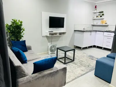 a living room with a couch and a tv at Reros Apartments in Mankweng in Mankweng