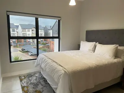 a bedroom with a large bed and a large window at The Blyde resort in Pretoria