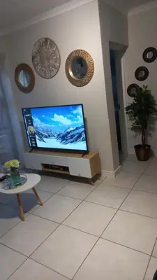 a living room with a flat screen tv and a table at The Blyde resort in Pretoria